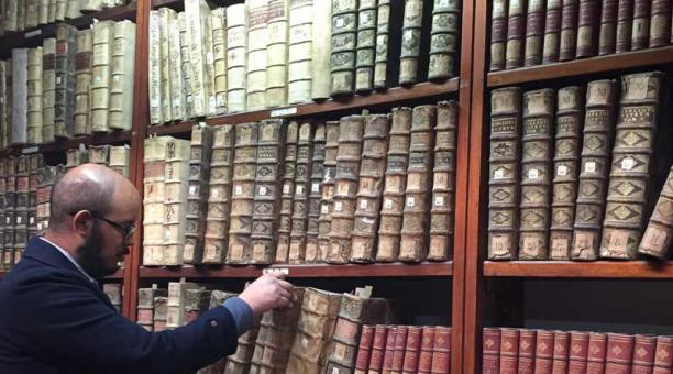 El guía de la biblioteca del convento Sto. Domingo ordena libros, algunos con tapas arrugadas. Foto: Betty Beltrán / ÚN