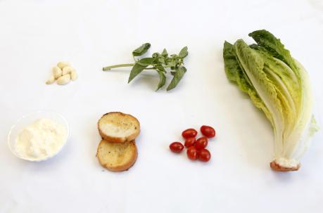 Ingredientes para la enzalada César de izq a der: Dientes de ajo, albahaca, lechuga romana, yogur, rodajas de pan y tomates cherry. Foto: Patricio Terán / UN