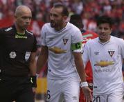 Hernán Barcos (centro) le reclama al árbitro Omar Ponce por la cartulina roja. Foto: API