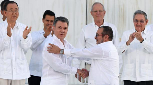Rodrigo Londoño y Juan Manuel Santos en un momento que será recordado en la historia. Foto: AFP