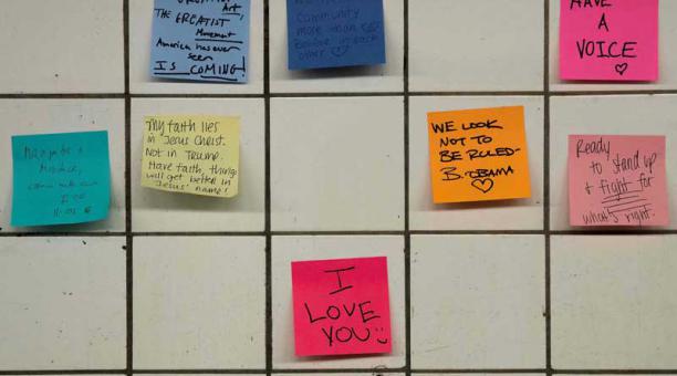 Decenas de pequeños papelitos multicolores en los azulejos blancos del túnel de la línea L, en Nueva York. Foto: AFP