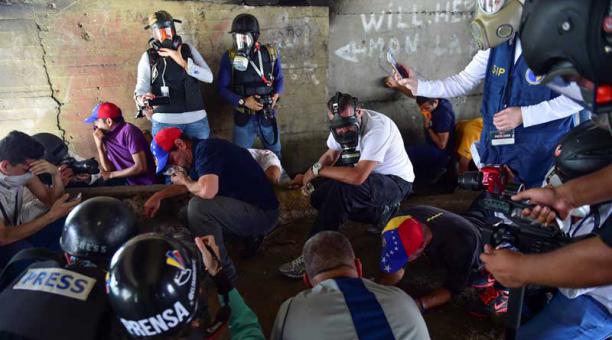 El líder de la oposición, Henrique Capriles, se refugia bajo un puente mientras la policía lanza gas lacrimógeno durante una manifestación contra el presidente venezolano Nicolás Maduro, en las calles de Caracas el 19 de abril de 2017. Foto: AFP