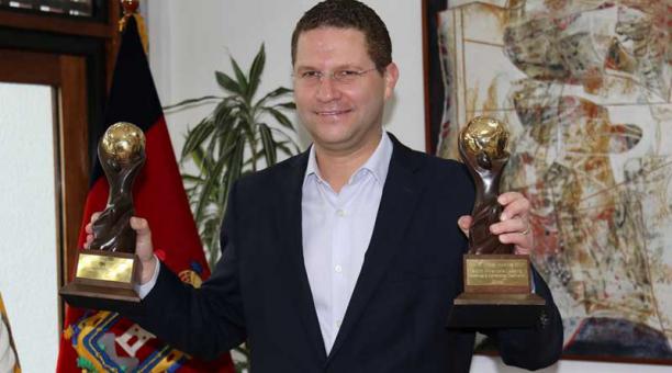 Mauricio Rodas sostiene hoy, lunes 11 de septiembre de 2017, las dos estatuillas que reconocen a la capital ecuatoriana como ganadora del World Travel Awards. Foto: EFE