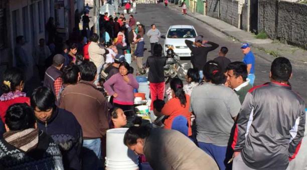 En la calle Joaquín Gutiérrez al sur de Quito, los moradores esperan a un tabaquero de agua para que llenen sus balde. Foto: Galo Paguay / ÚN