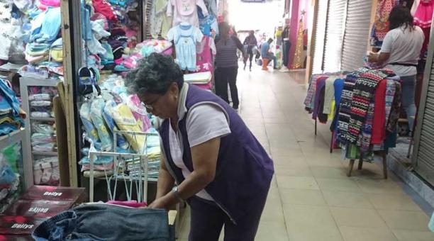 La comerciante Angélica Tutillo acomoda la ropa de niños en su local. Foto: Ana María Carvajal / ÚN