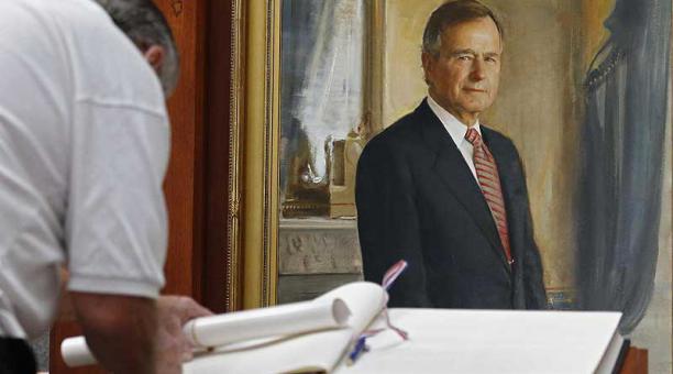 Un hombre firma en el libro de condolencias del expresidente George Bush. Foto: EFE