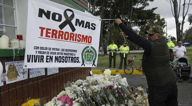 Un hombre extiende una pancarta durante un homenaje a los cadetes muertos por la explosión del carro bomba contra la Escuela de Cadetes de la Policía General Santander, en Bogotá (Colombia). Foto: EFE