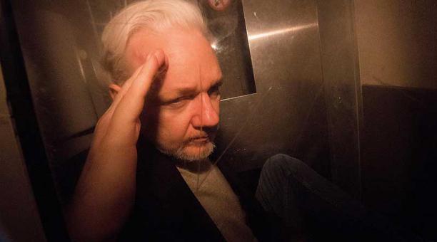 Julian Assange saluda mientras abandona en un vehículo policial el tribunal de Southwark de Londres, Reino Unido. Foto: EFE