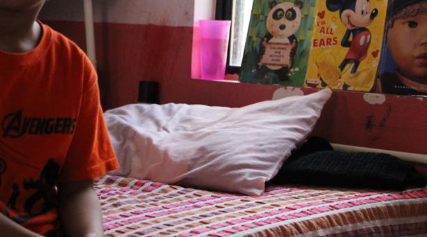 Un niño migrante, al filo de la cama de un albergue. Foto: Abrhan Pineda / EFE