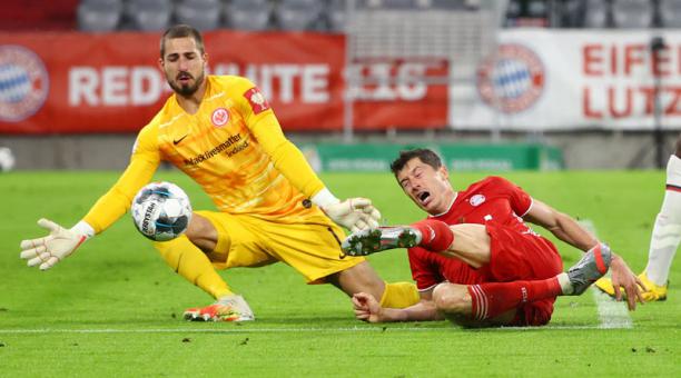 El delantero del Bayern Munich Robert Lewandowski (der), busca anotar ante la salida del golero del Frankfurt Kevin Trapp, en la Copa de Alemania, el 10 de junio del 2020. Foto: AFP