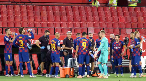 Jugadores del Barcelona durante una pausa para refrescarse durante el cotejo ante  Sevilla FC. Foto: AFP