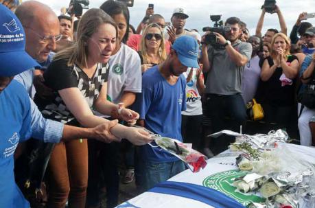 Girlie Rangel (3i) coloca flores de la boda de su esposo, el goleador del equipo Chapecoense, Bruno Rangel, ayer, domingo 4 de diciembre de 2016, en su entierro en la ciudad de Campos. Foto: EFE