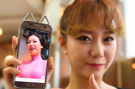 Hong Hye-Jin (So-Ah), miembro del grupo de K-pop SixBomb, con una foto de sí misma antes de su cirugía plástica en un salón de belleza en Seúl