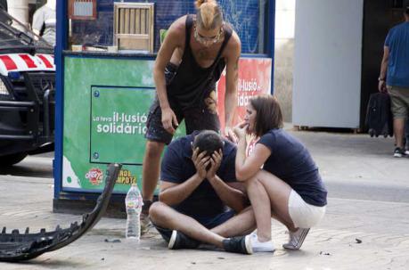 Varios jóvenes permanecen junto a los restos de un vehículo, en el lugar del atropello masivo realizado por una furgoneta en España. Foto: EFE