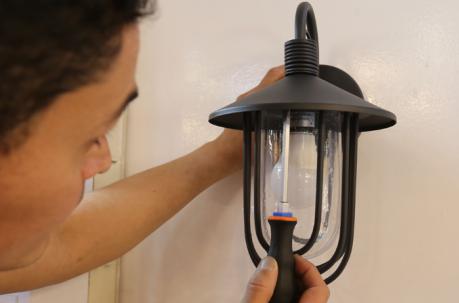 Ajuste los tornillos de la pieza que recubre el farol- Instale el foco en la lámpara.