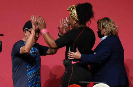 La medallista olímpica choca palmas con su entrenador, luego de su participación en el Foro Internacional de Tokio. Foto: EFE