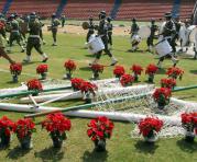 Un hombre decora los postes de un arco de fútbol, mientras miembros de la banda marcial del ejército colombiana ensayan hoy, miércoles 30 de noviembre de 2016, durante los preparativos del homenaje al equipo de fútbol Chapecoense que tendrá lugar en la no