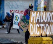 Manifestantes opositores se enfrentan a agentes de la Guardia Nacional Bolivariana mientras bloquean una calle en rechazo a las elecciones de la Asamblea Nacional Constituyente ayer, domingo 30 de julio de 2017, en Caracas (Venezuela). Foto: EFE