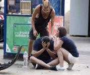 Varios jóvenes permanecen junto a los restos de un vehículo, en el lugar del atropello masivo realizado por una furgoneta en España. Foto: EFE